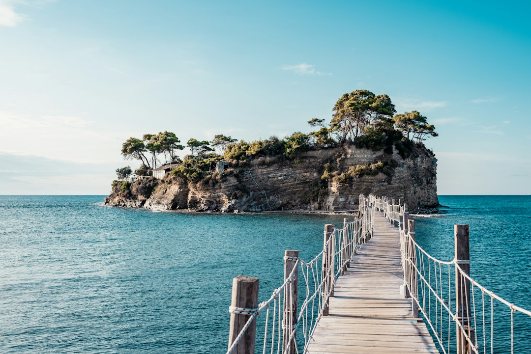 brown-wooden-bridge-over-blue-sea-under-blue-sky-during-daytime-fn27dli8bz8