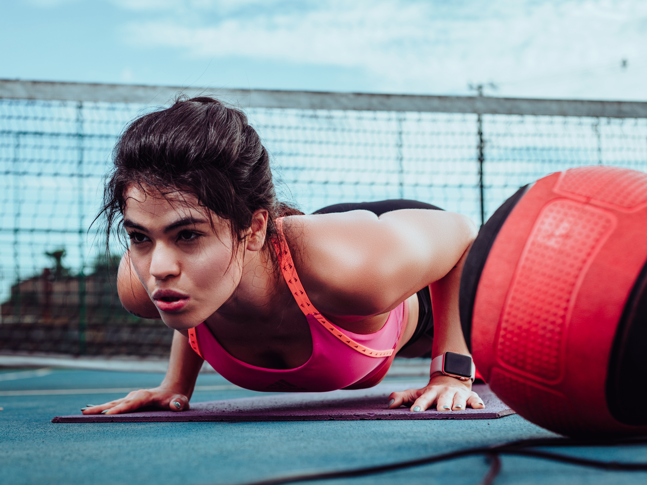 Contact Woman doing push-ups on a sports court in Ji-ParanĂ¡, Brasil, focusing on fitness outdoors.